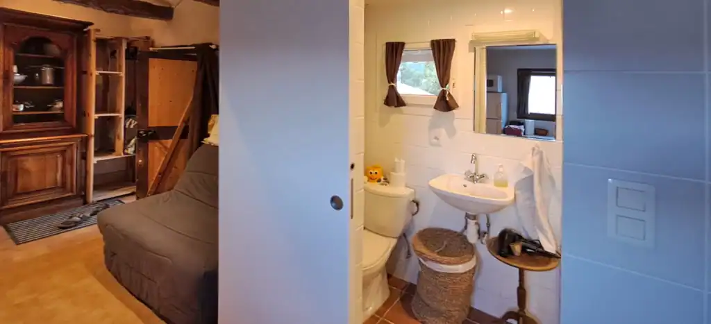 Salle d'eau du studio et canapé plié.